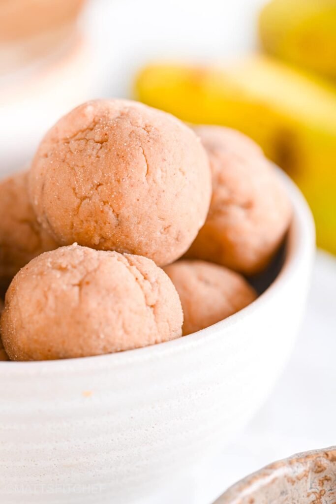 3-Ingredient Banana Protein Balls {8.3g Protein} High protein oatmeal balls in white ceramic bowl, shown from close