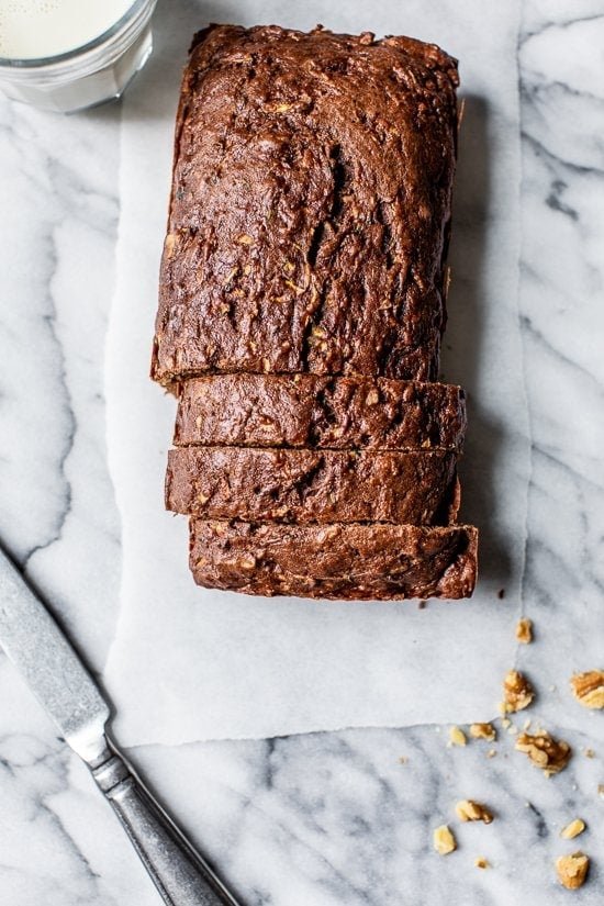 Chocolate Zucchini Bread (Healthier Recipe) Overhead view of sliced Chocolate Zucchini Bread loaf on white marble