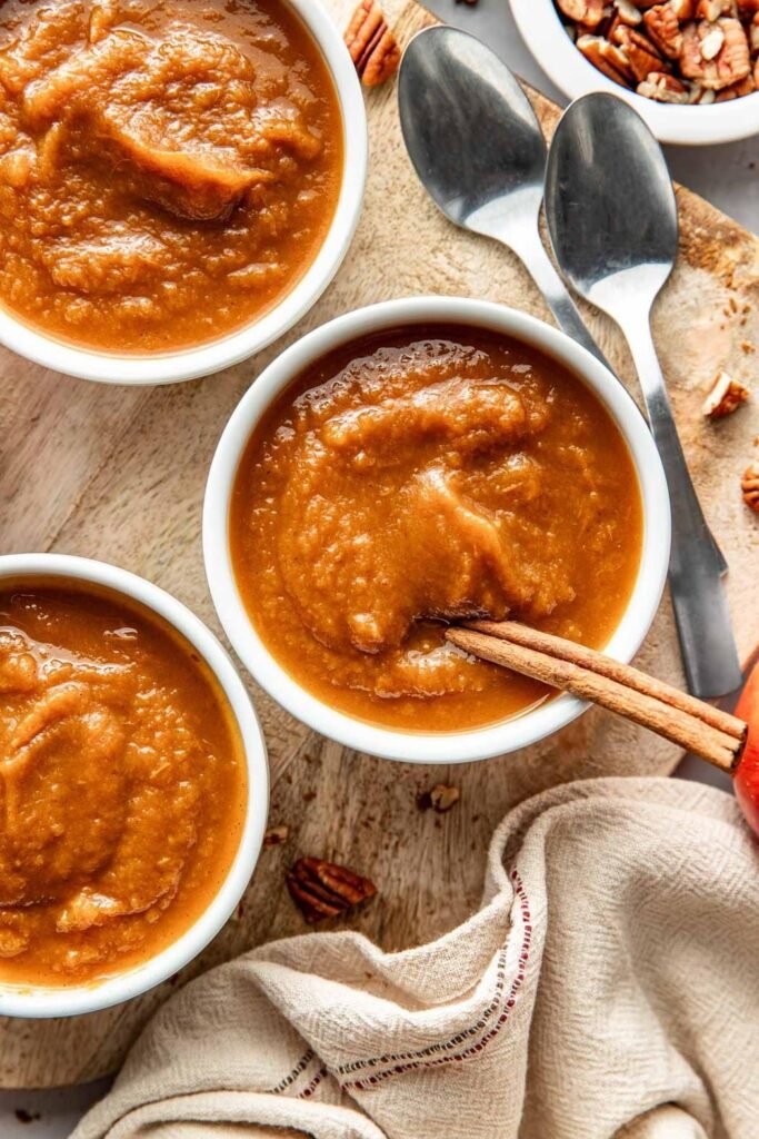 Overhead view of two small bowls of fresh crockpot pumpkin applesauce.