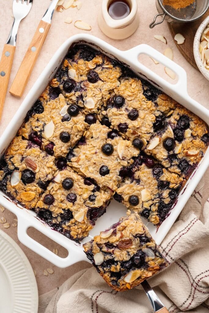 Overhead view of a white baking dish filled with blueberry baked oatmeal cut into 9 squares.